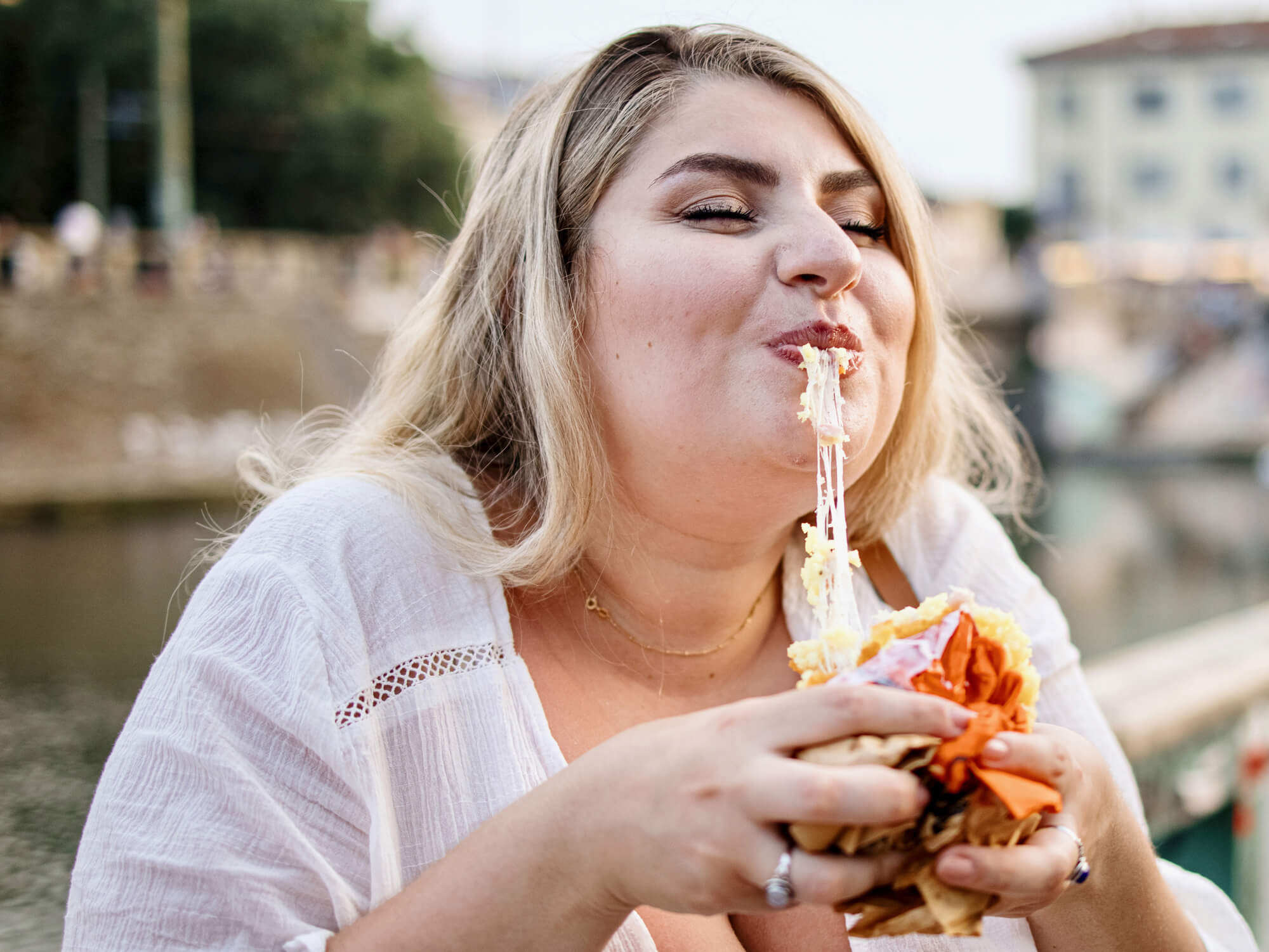 DoughBalls Pizza Restaurant Adelaide Contact Page. Image of a young girl taking a bit of pizza and obviously enjoying it by the look on her face.