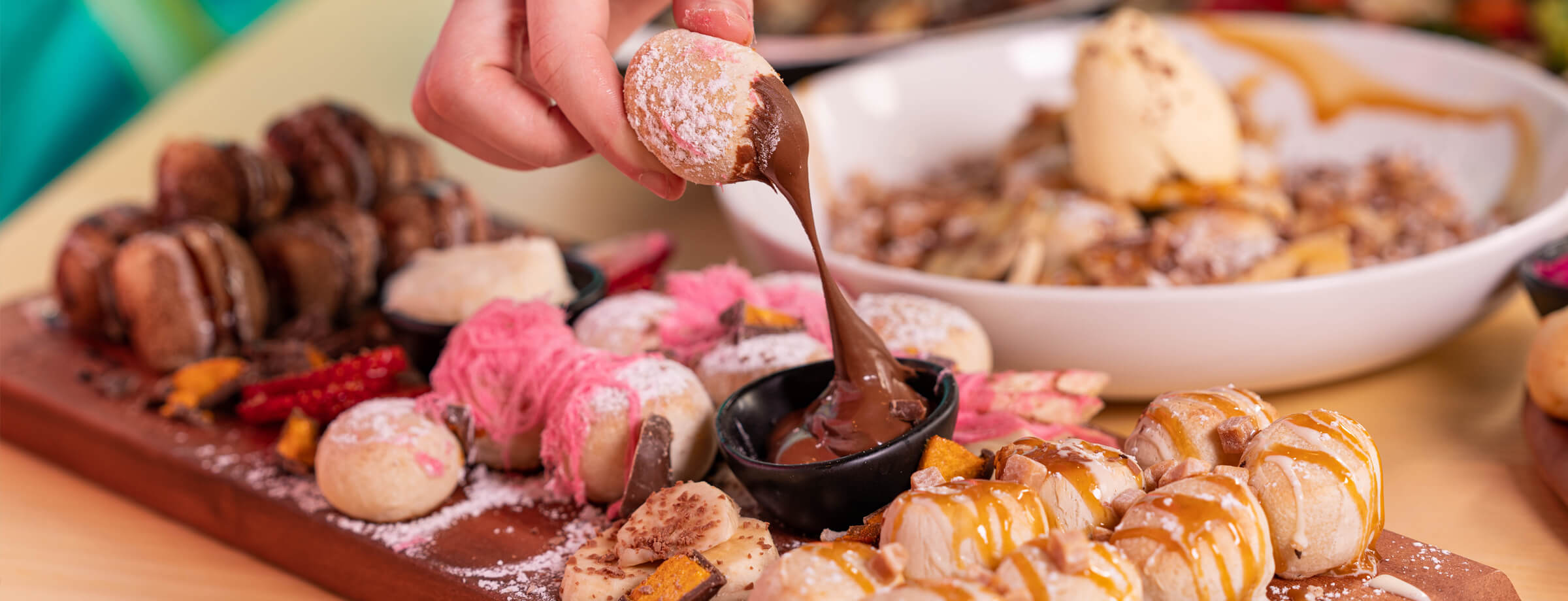 DoughBalls Pizza Restaurant Adelaide homepage image of a customer dipping into delicious Doughballs chocolate sauce.